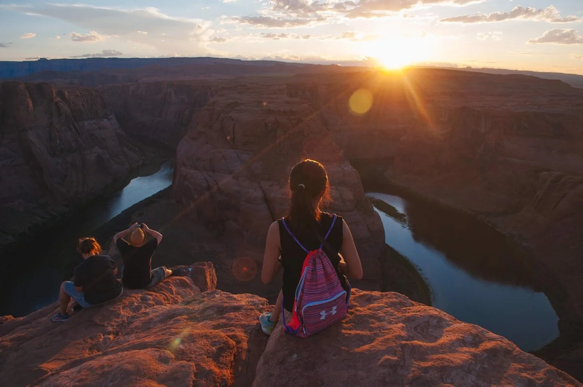 Solo traveler overlooking a scenic mountain landscape at sunrise